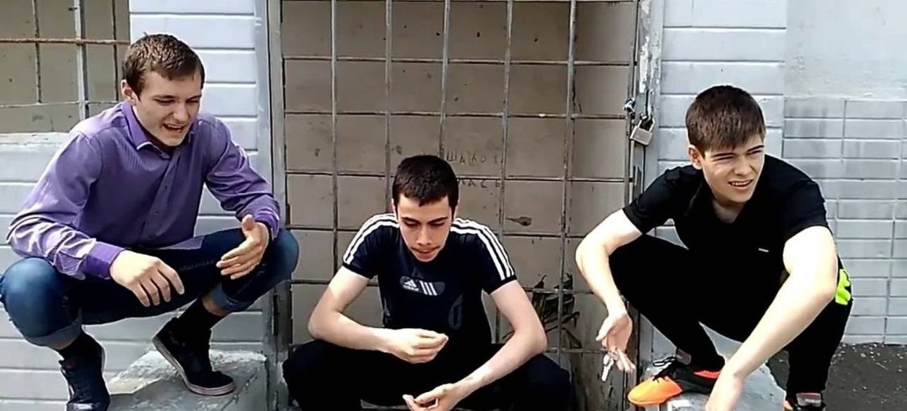 Подростки сидят на корточках