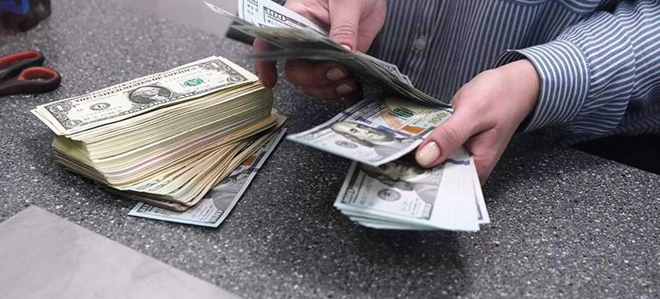 Человек пересчитывает доллары