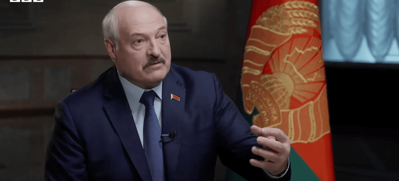 Лукашенко выступает на фоне флага Беларуси