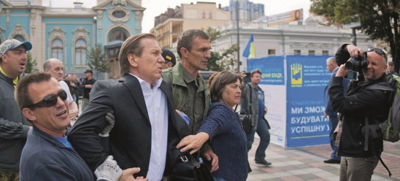 Депутата Виталия Журавского бросают в мусорный бак / Фото: 2000.ua