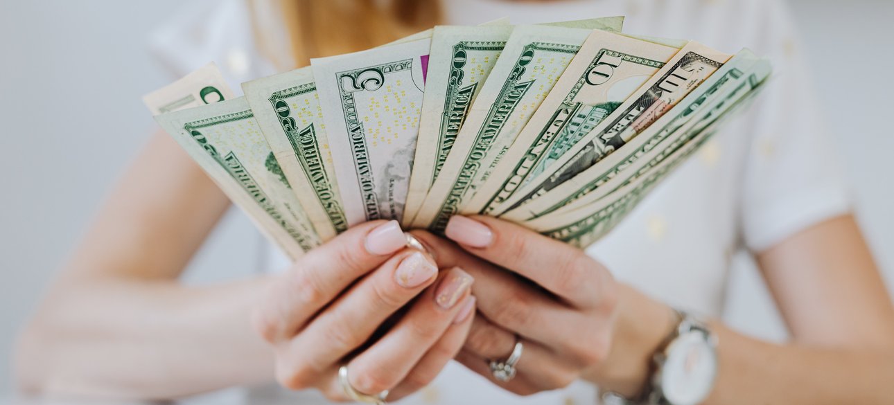 Долларовые купюры в руках женщины