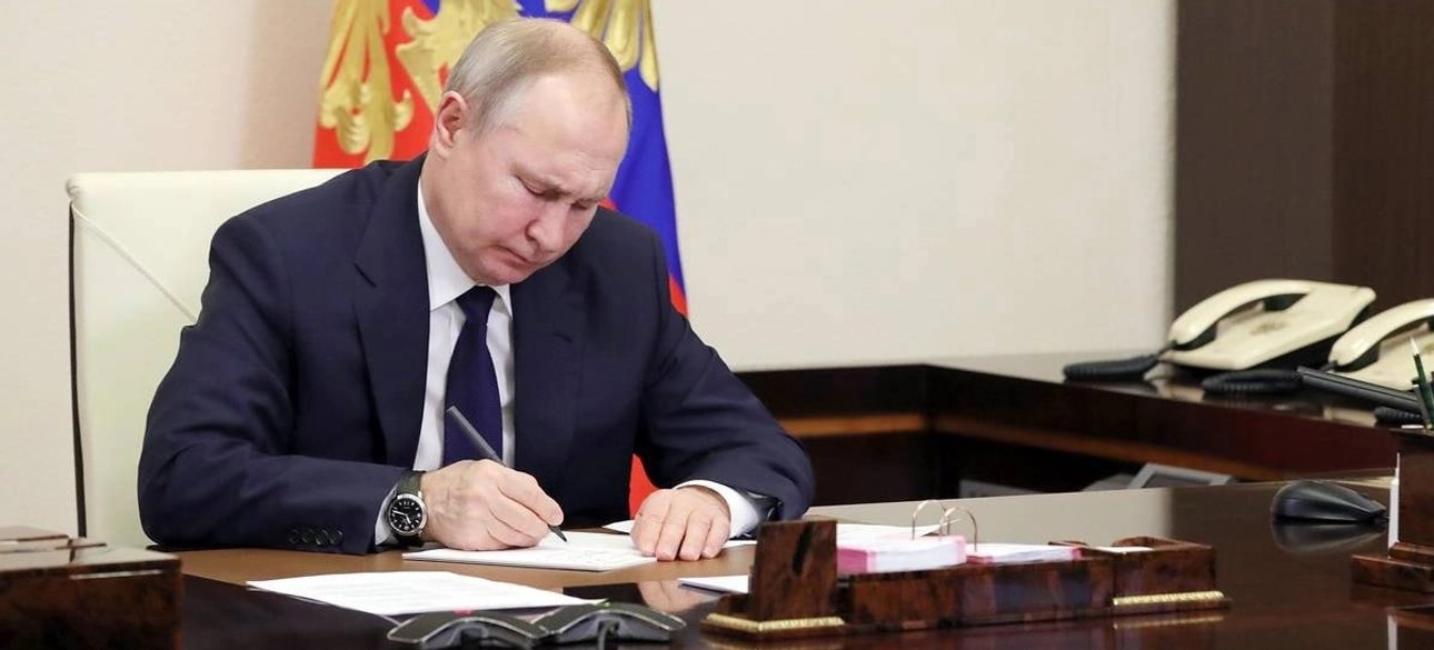 Путін підписує документ у кабінеті Кремля