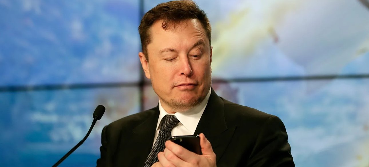 Ілон Маск читає смартфон