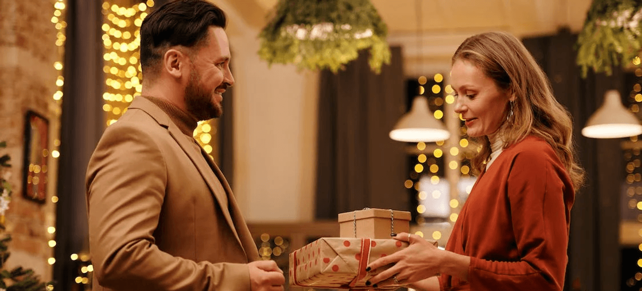 Мужчина дарит женщине новогодний подарок