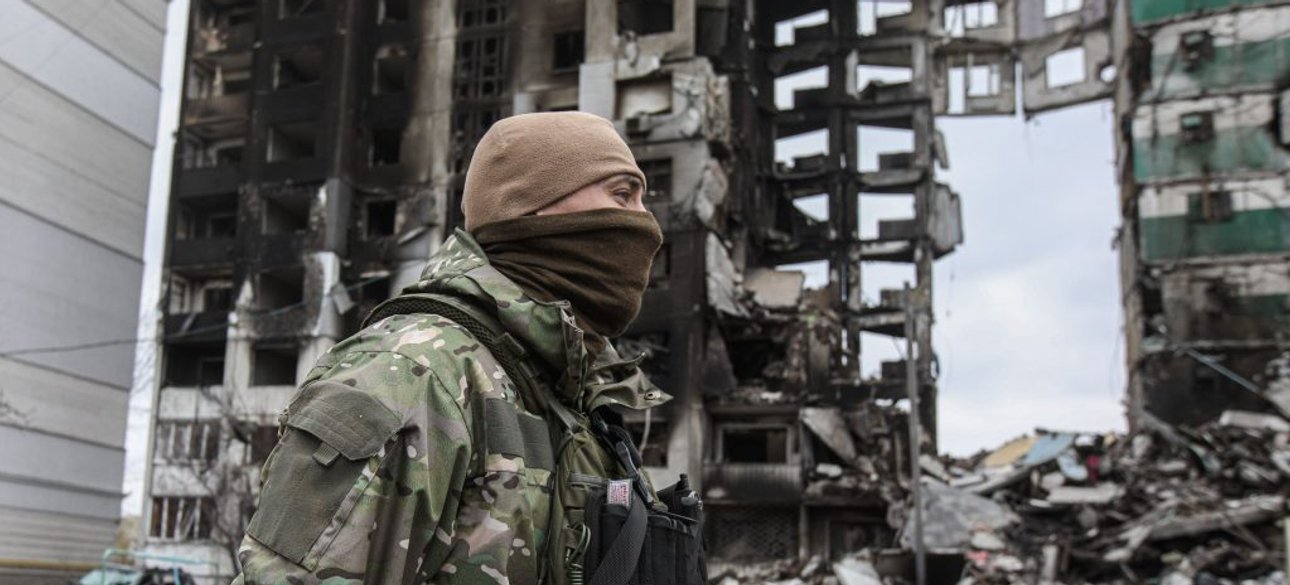 Украинский военнослужащий на фоне разрушенного здания