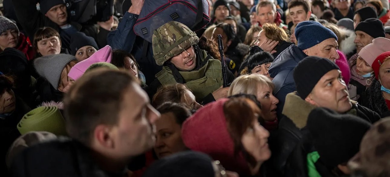 натовп цивільних та самотній солдат на вокзалі