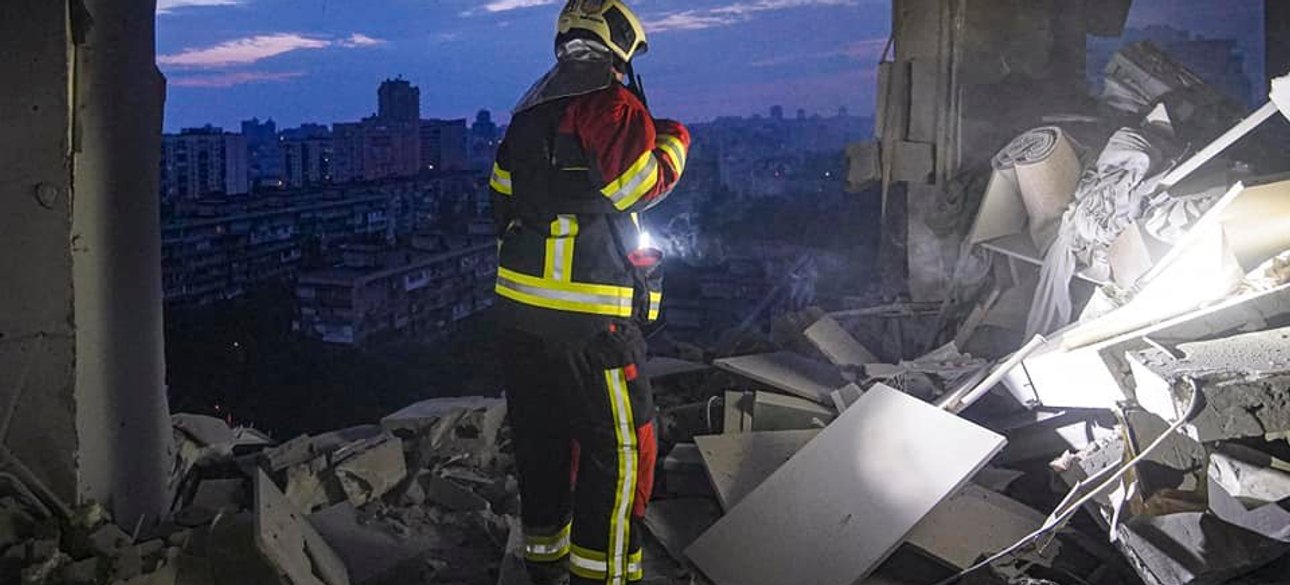 Рятувальник на верхньому поверсі будинку в Києві, що постраждав від обстрілу