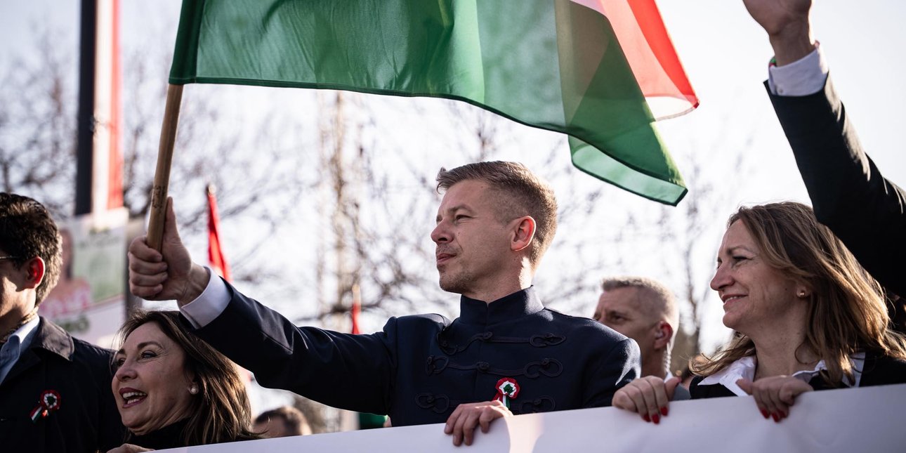 Петер Мадьяр с флагом Венгрии на митинге