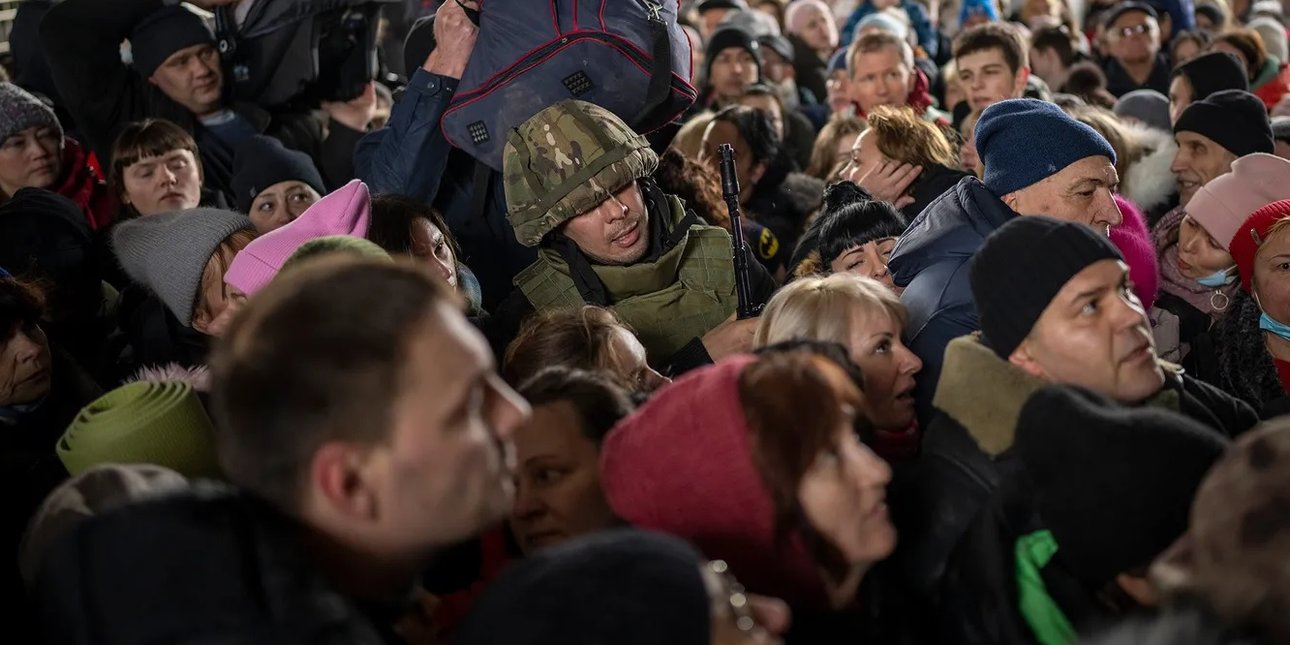 толпа гражданских и одинокий солдат на вокзале