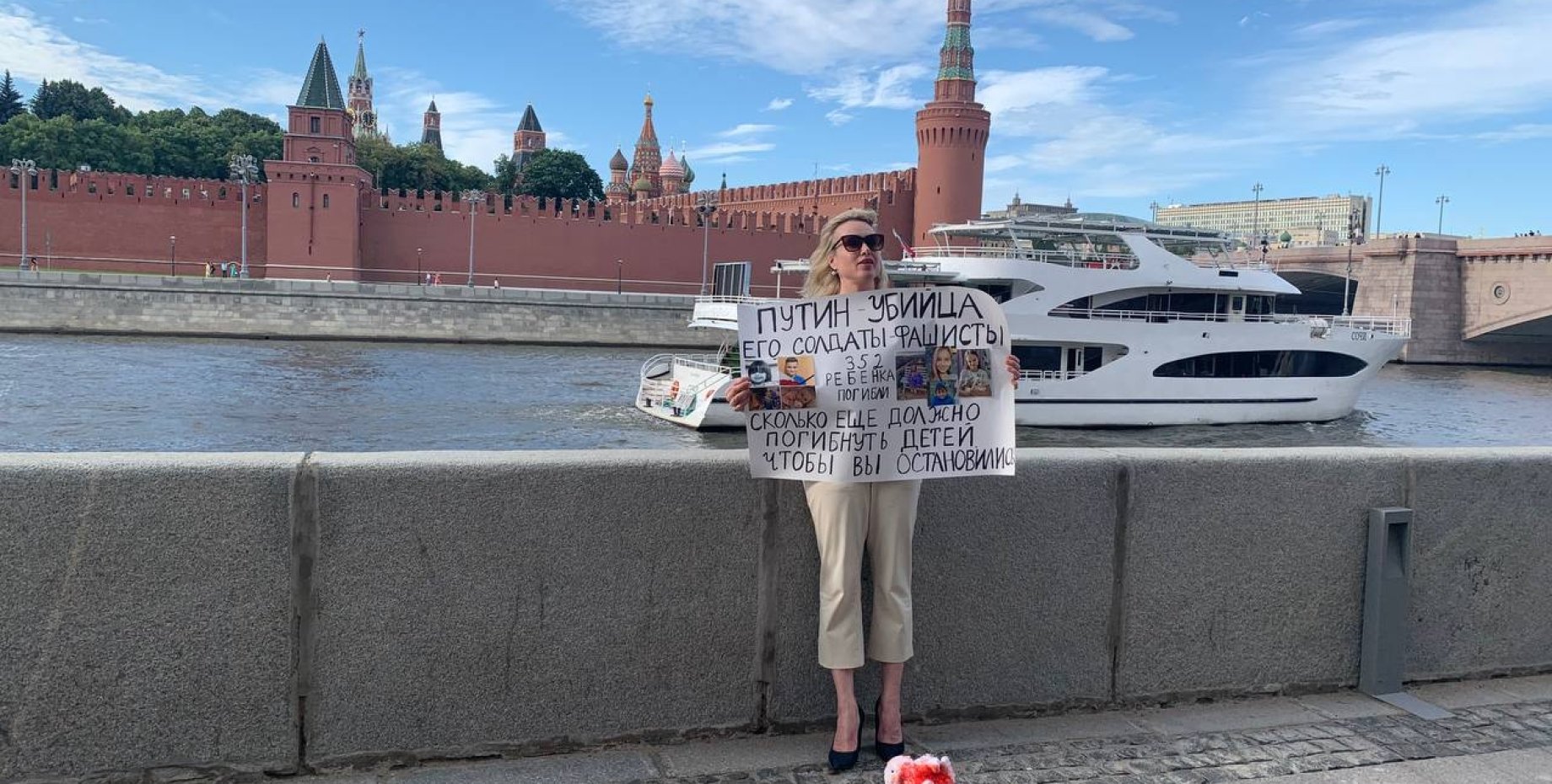 Март обвинил. Овсянникова с плакатом на набережной Москвы. Фотосессия возле Кремля. Софийская набережная.