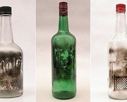 Художник рисует картины дымом внутри стеклянных бутылок