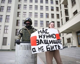 В Минске перед Домом правительства ОМОН опустил щиты. Девушки с цветами обнимают омоновцев