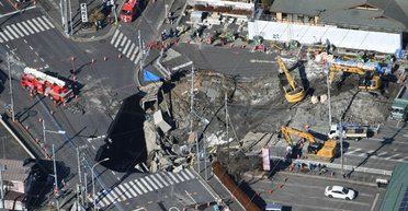 В Японии трое суток не могут достать водителя грузовика из огромного провала на дороге (видео)