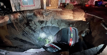 Почалася евакуація: величезна вирва поруч із будинком "поглинула" дві машини (фото)
