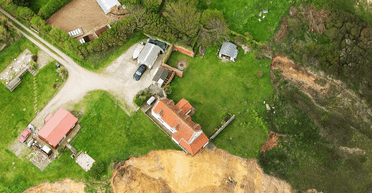 Може впасти на пляж: будинок залишився висіти над краєм обриву після зсуву ґрунту (фото)