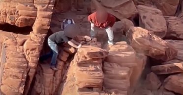 "Татку, не впади": двоє чоловіків із дитиною руйнували стародавню скелю, скидаючи з неї валуни