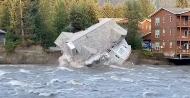 Развалился на части: дом рухнул в реку во время наводнения (фото)