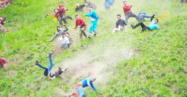 "Безумие": в Англии люди сломя голову качались с холма в гонке за грудой сыра, — Sky News (фото)