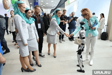 Робот Володя жмет руки посетительницам экономического форума