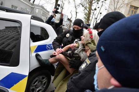полицейские сажают в машину активистку Femen