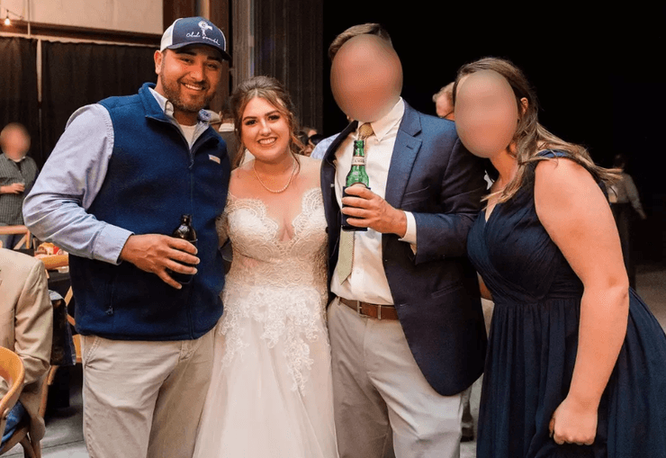 Невеста в белом платье улыбается, позируя на свадьбе рядом с друзьями и мужчиной, который позже станет ее супругом