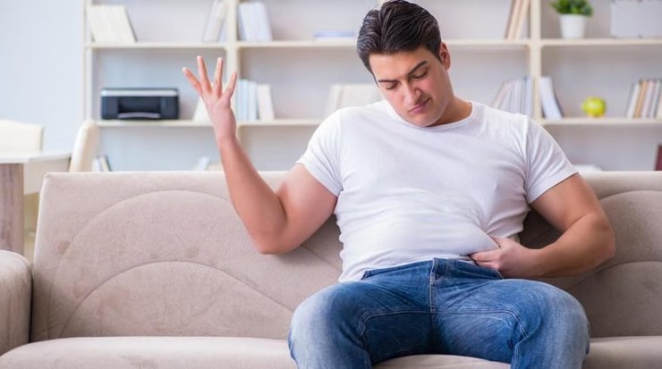 Чоловік займається вправами для схуднення на килимку вдома