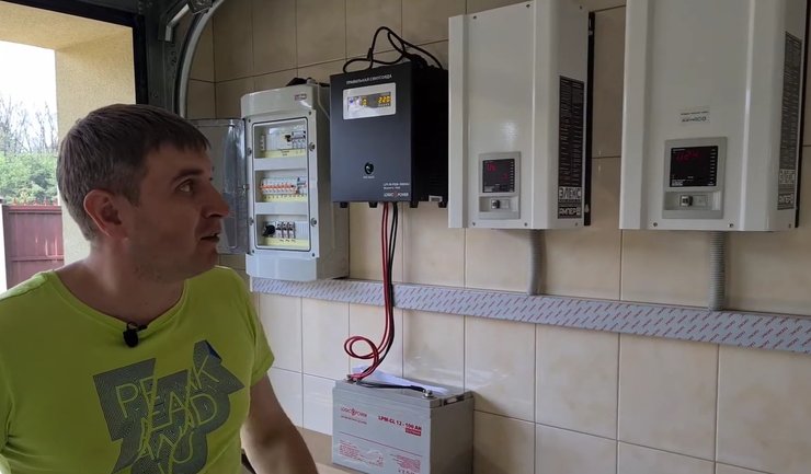 Чоловік показує стабілізатори напруги Елекс Engineering Ампер У 12