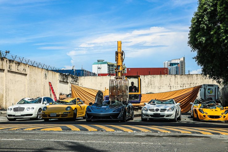 Слева направо: Bentley Continental Flying Spur, Porsche 911 Carrera S, McLaren 620R, Mercedes SLK, Lotus Elise. И главный герой — экскаватор