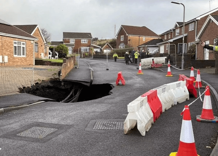 Величезна воронка посеред вулиці, яма в дорозі, величезна діра в дорозі, евакуація місцевих жителів, будинки може поглинути воронка