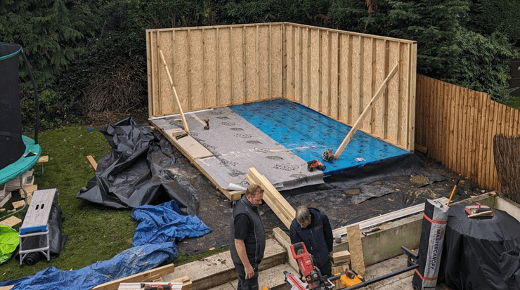 Пара возводит стены будущей садовой комнаты на заднем дворе