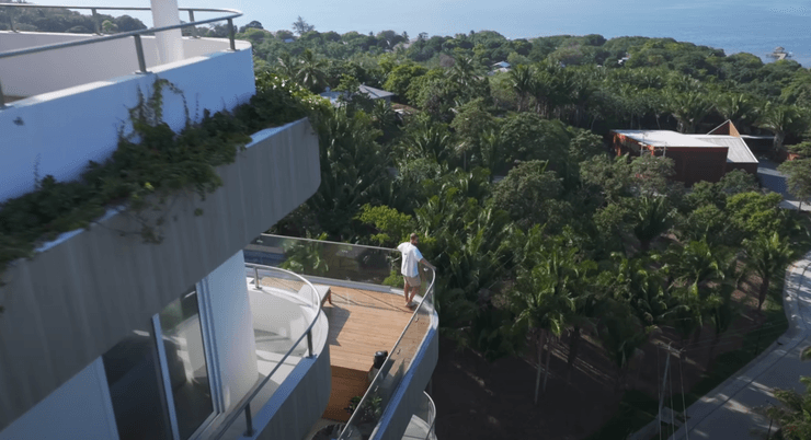 Мужчина стоит на балконе современного здания в Проспере, экспериментальном городе Гондураса