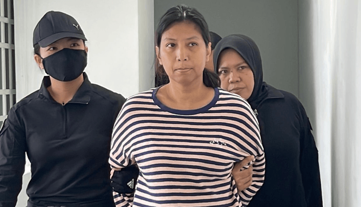 Нурхасвани Афни Мохамад Зорки под конвоем полиции после обвинений в нападении на султана Перака