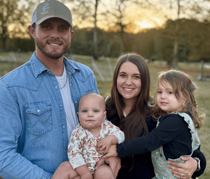 Супружеская пара с двумя детьми на собственном участке, где они выращивают еду и живут самодостаточно