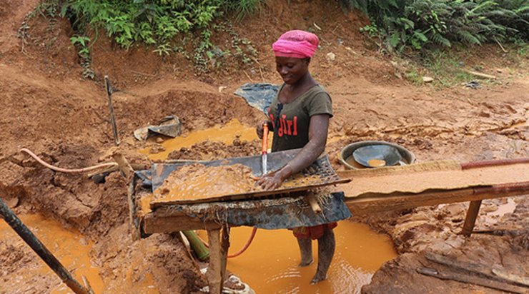 Жінка промиває золото вручну на нелегальній копальні в Західній Африці
