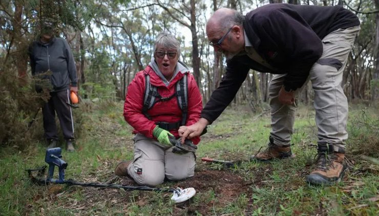 Пенсионерка с металлоискателем радуется первой находке золотого самородка во время поиска в Австралии