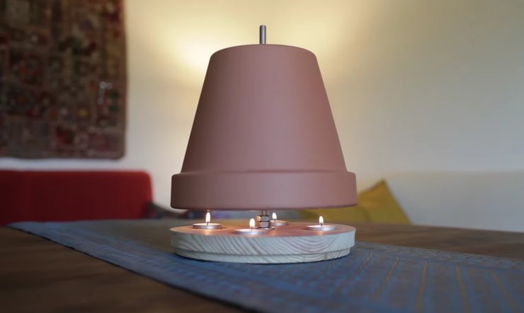 Свічковий обігрівач зі свічками, що горять, на столі