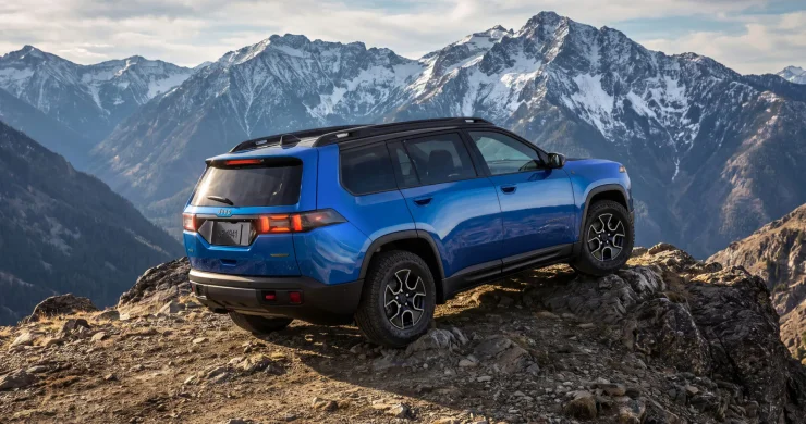 Синій позашляховик Jeep Cherokee Trailhawk стоїть на скелястому гірському схилі
