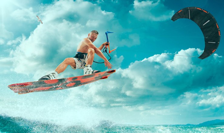 спортсмен держится за трос воздушного змея