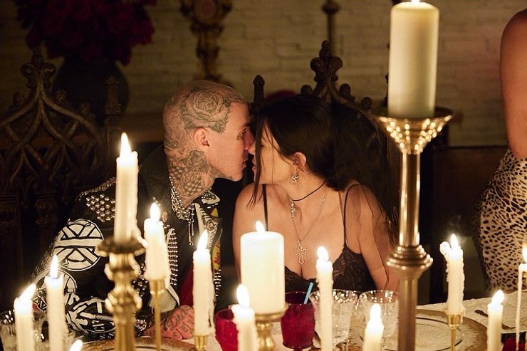 Кортни Кардашьян целует супруга на готической вечеринке.