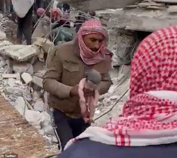 Новорожденный ребенок на фоне разрушений в Сирии