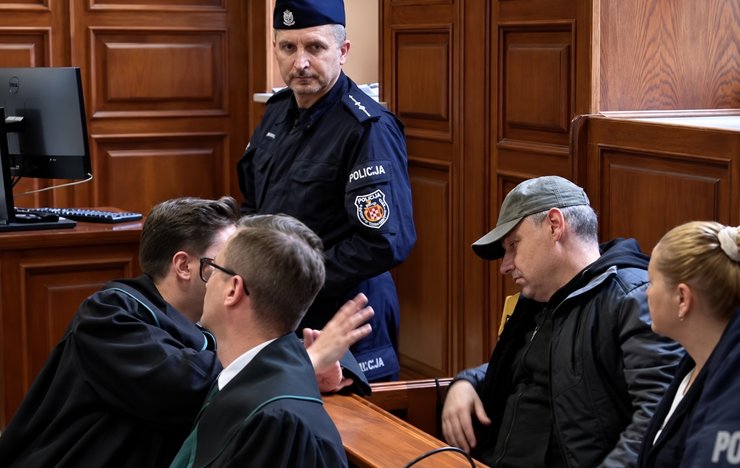 Володимир Журавльов у супроводі польської поліції в будівлі суду у Варшаві у жовтні 2025 року