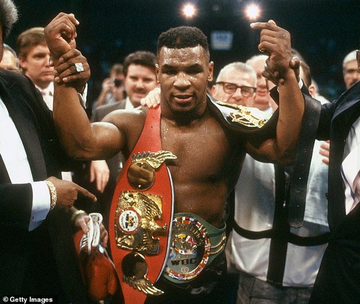 Майк Тайсон с чемпионскими поясами.