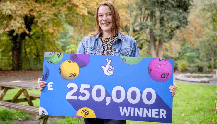 Медсестра Ребекка Хулатт з Англії тримає чек на 250 000 фунтів після виграшу в миттєвій лотереї