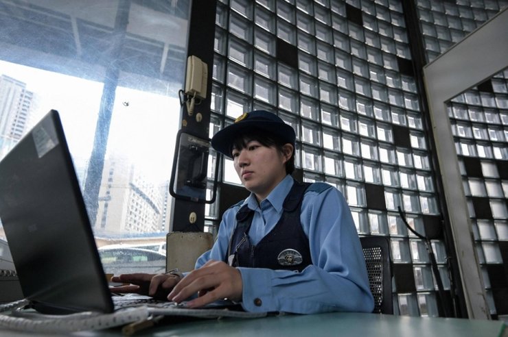 Полицейский работает в полицейской будке в районе Иидабаси в центре Токио. | AFP-Jiji