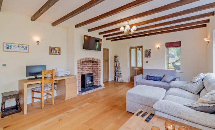 Гостиная оборудована деревянным полом и деревянными балками