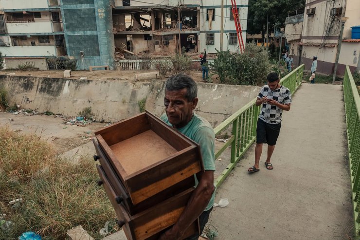 Вилман Гонсалес переносит уцелевшую мебель из своего разрушенного дома