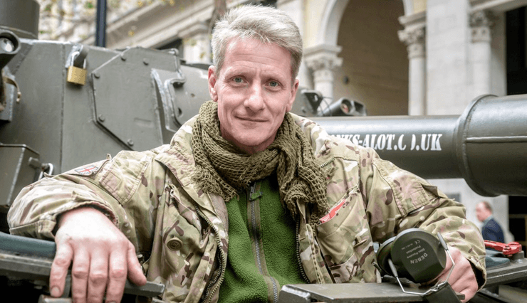 Коллекционер бронетехники Ник Мид в камуфляже позирует рядом с военной техникой
