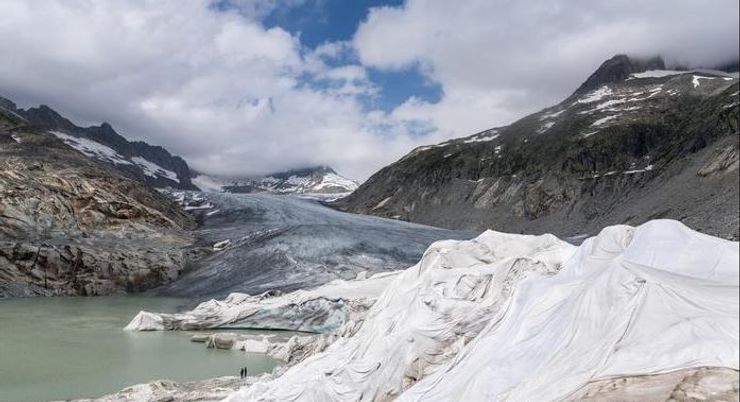 Части Ронского ледника в швейцарских Альпах, изображенные на фото, покрыты белыми устойчивыми к ультрафиолетовому излучению одеялами, чтобы защитить его от таяния.