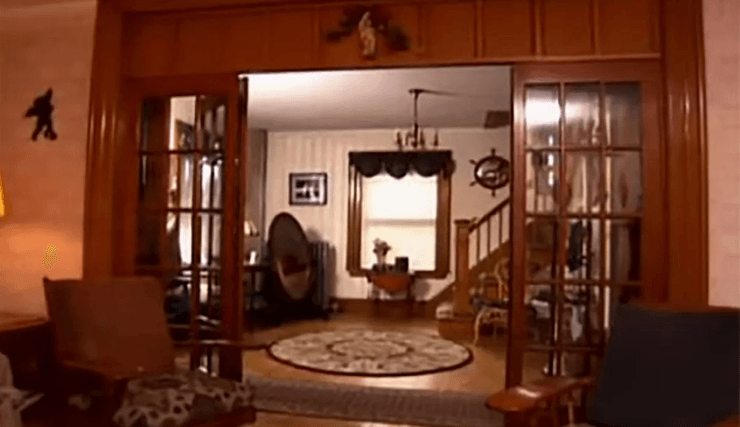 Гостиная и прихожая внутри старинного дома с деревянными дверями и винтажным оформлением