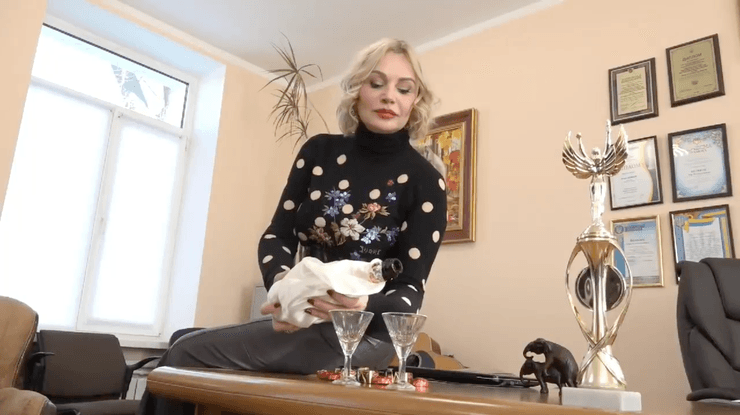 Женщина наливает шампанское в бокалы.